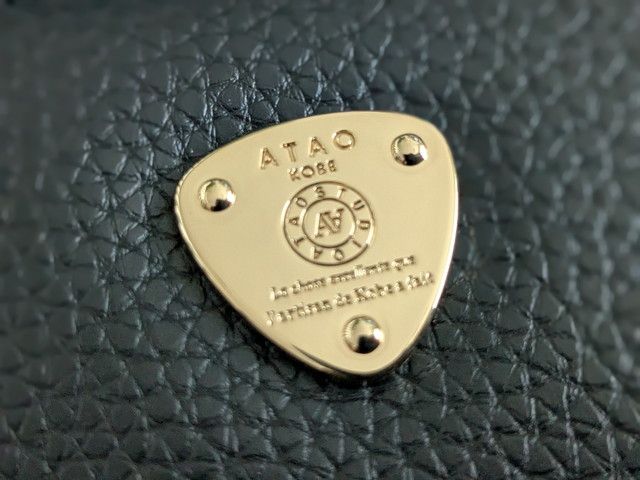 ATAOの三角プレートのアップ。ATAO KOBEの文字とロゴが刻まれたゴールドプレート