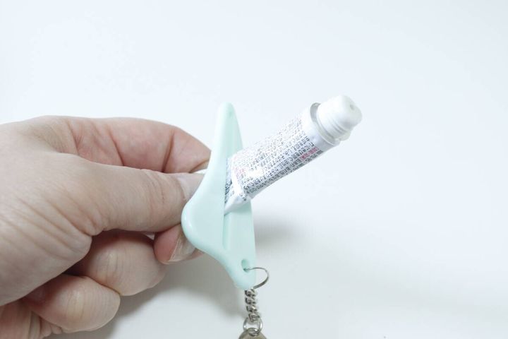 ダイソーのチェーン付きかっさでチューブを絞る様子