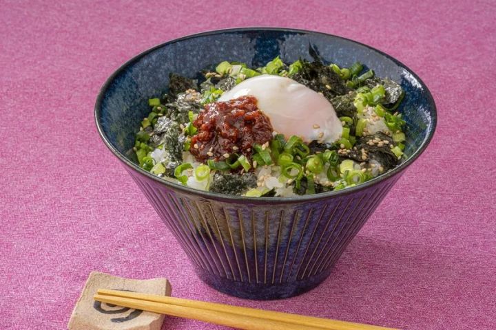 夏メシ革命を白米の上にのせた温泉卵・刻み海苔・小ねぎ添えのごはん丼アレンジ料理写真。青い陶器ボウルにピンク背景で盛り付け