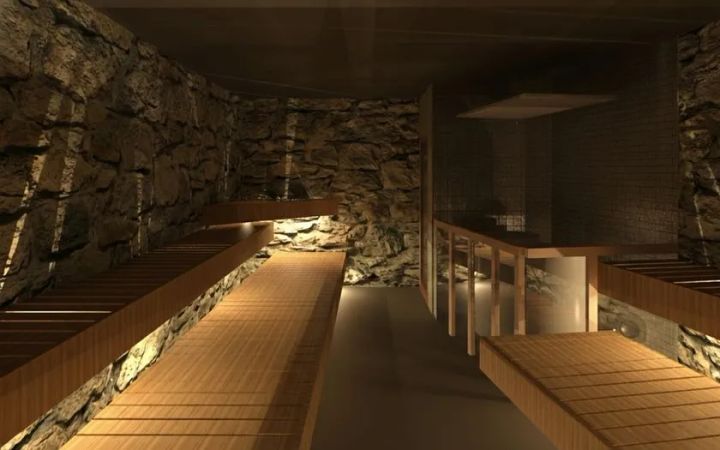 洞サウナ（DO SAUNA）の内装完成予想図。天然石積みの壁に囲まれた洞窟型サウナ室で、両側に木製段状ベンチが並び、間接照明が足元を照らす構造。