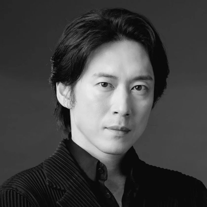 宮尾俊太郎のモノクロ近影。ダークグレー背景に黒いリブニット姿で正面を向いたポートレート写真。