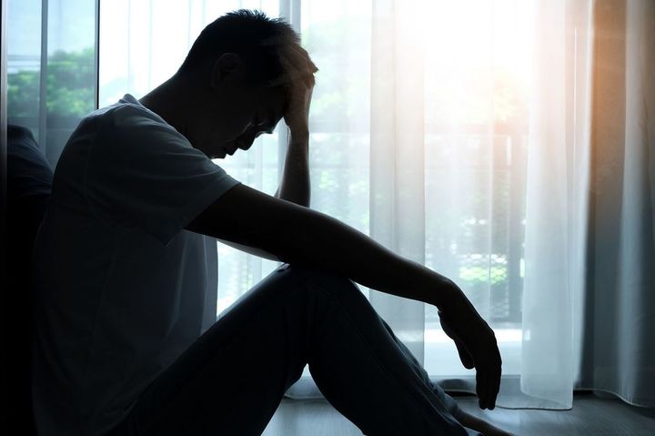 部屋の隅に座っている鬱々とした男性