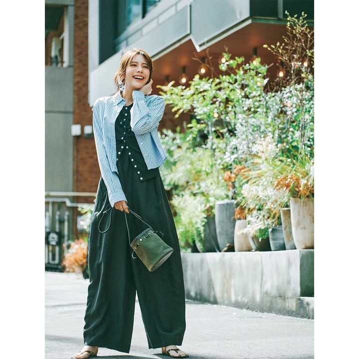 ワイドパンツのオールインワンにスナップカーディガンとストライプのクロップド丈シャツをレイヤードした着こなし