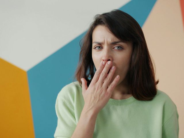 口を抑える女性
