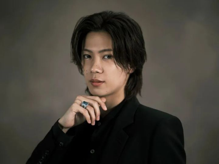 Number_iの神宮寺勇太がミキモトのハイジュエリーリングを着用し、黒スーツ姿でグレー背景の前に立つポートレート写真