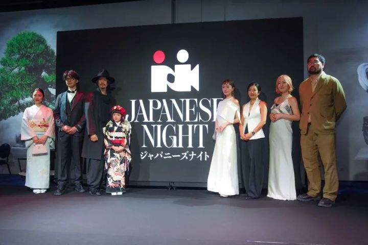 JAPANESE NIGHTロゴバックパネルの前に着物姿の女性2名・子ども1名とドレス・スーツ姿の出演者計8名が横一列に並ぶ集合写真