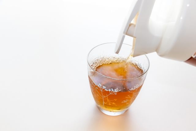 ポットから麦茶をコップに注ぐ様子