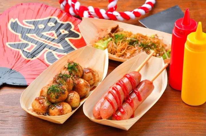 祭り扇と紅白縄を背景に、たこ焼き・フランクフルト串・焼きそばを木製舟皿に盛りつけた屋台フード3種のセット写真