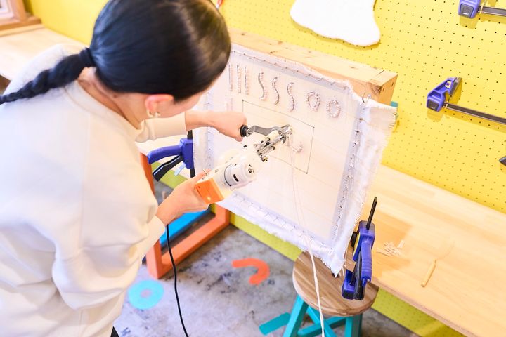 中央のライン部分にベージュの毛糸を打ち込んでいく