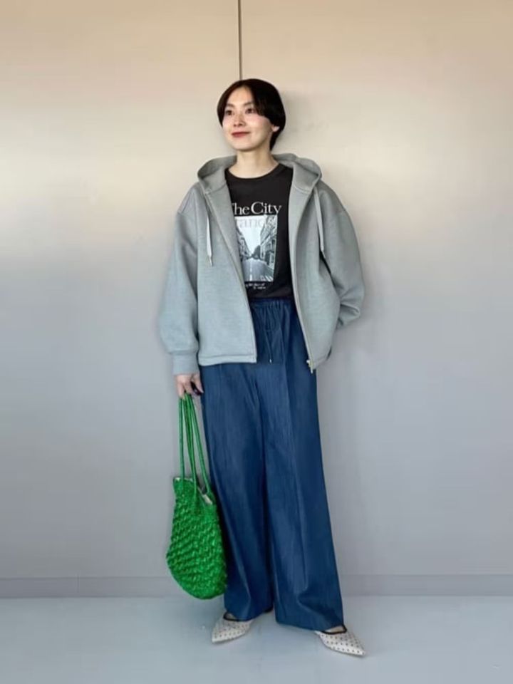 鮮やかなグリーンのバッグなど小物をアクセントに