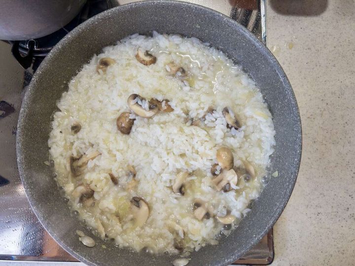 グリーンピースの茹で汁を加えてごはんを煮込んでいる様子