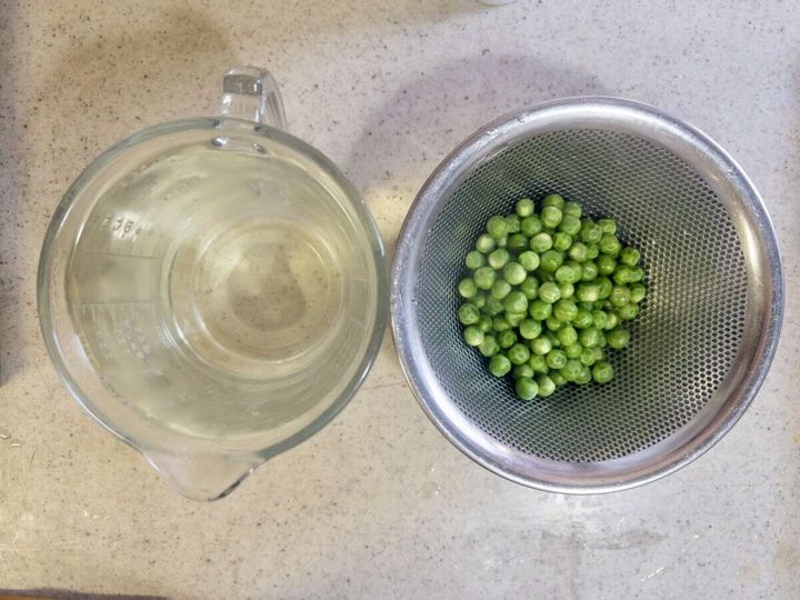 茹で上がったグリーンピースと取り置いた茹で汁の計量カップ
