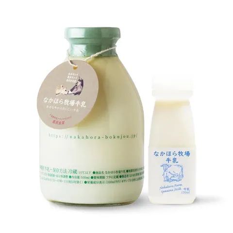 なかほら牧場牛乳の500ml瓶と100mlミニ瓶を並べた商品写真。ガラス瓶に成分・保存方法などのラベルが貼られ、タグが付属している
