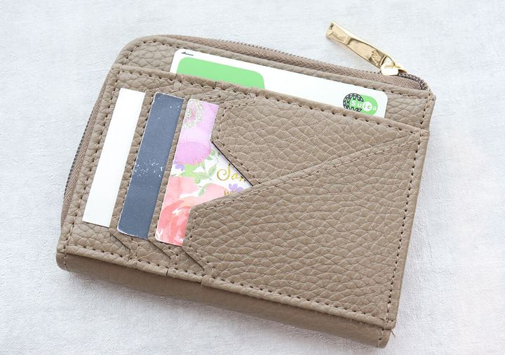 トープ色のATAOミニ財布の背面カードポケットにSuicaや花柄など複数のカードを収納した斜め俯瞰写真