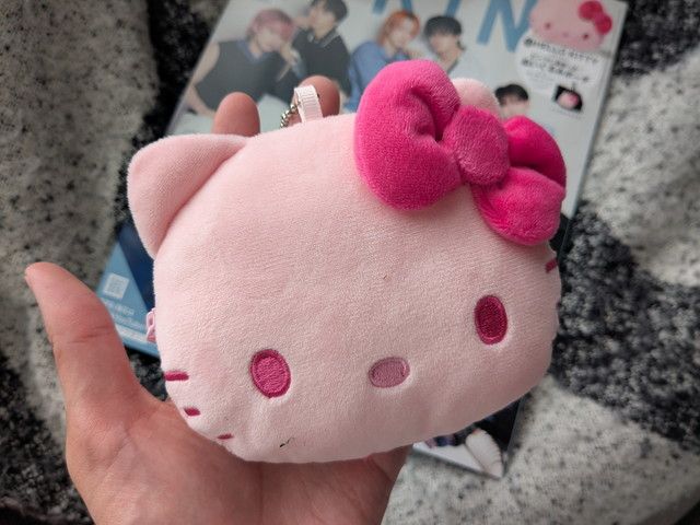 HELLO KITTYぬいぐるみポーチの正面アップ。ピンクのぬいぐるみ素材にホットピンクの大きなリボンが特徴的