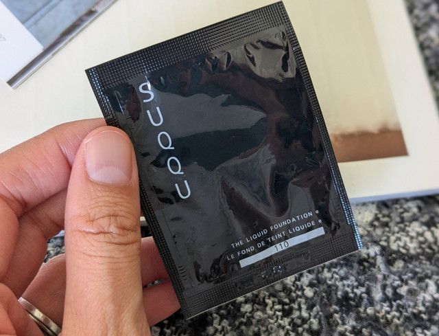 SUQQUザリクイドファンデーションe 110のパッケージ。黒のパッケージにSUQQUのロゴが入っている