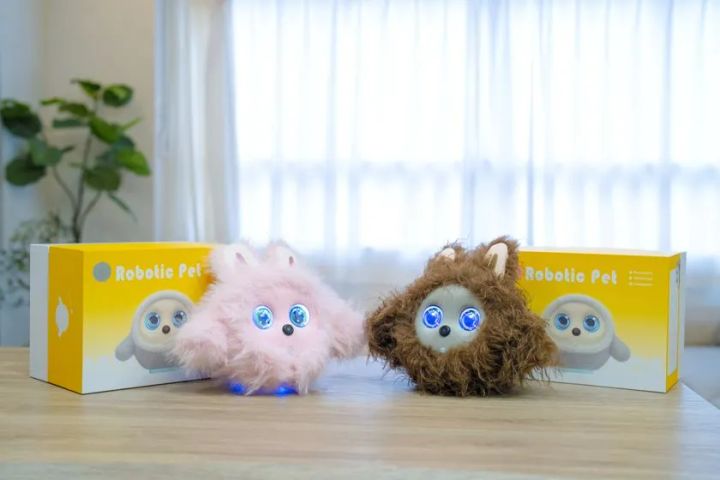 KOTTIピンクとブラウンの2色展開モデルを、黄色い化粧箱Robotic Pet×2個とともに並べた製品ラインナップ比較ショット