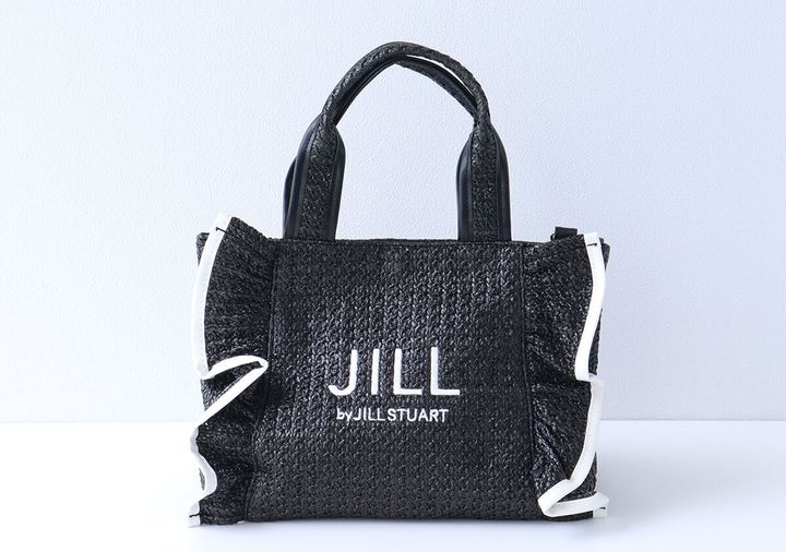 白いJILL by JILL STUARTロゴ刺繍が入り両サイドに白パイピングの立体フリルが付いた黒いラフィア風かごバッグの正面写真