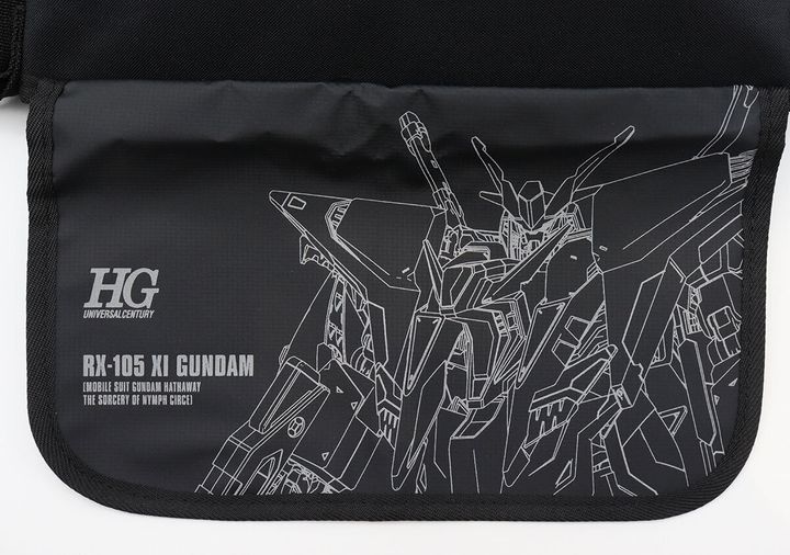 メッセンジャーバッグのフタ部分にHG UNIVERSAL CENTURY・RX-105 XI GUNDAMの文字とガンダムのリフレクタープリントが入った正面アップ写真