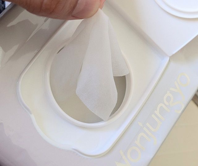 Wonjungyo モイストアップレディスキンパックのシートを取り出している様子。薄くやわらかなシートが確認できる