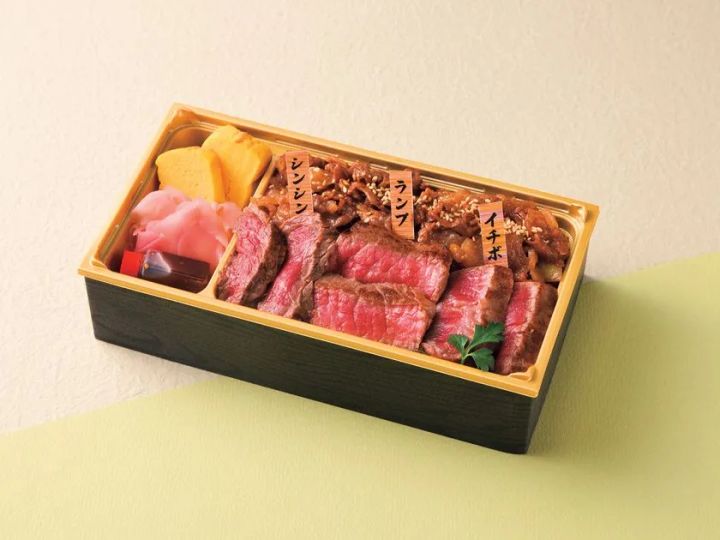 博多和牛弁当の商品写真。黒塗り重箱にシンシン・ランプ・イチボの3部位が部位名の木製ラベル付きで並び、南蛮漬け風の小鉢と南瓜煮付きを添えた構成。