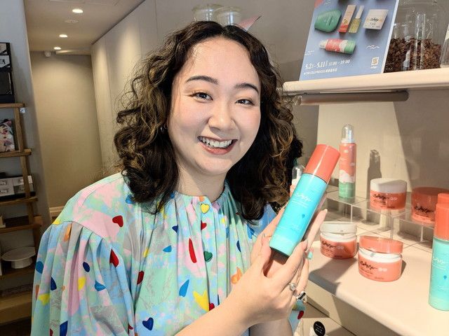 Curly Me代表のカーリーガールリンさんがアクアリーミルクセラムを手に笑顔