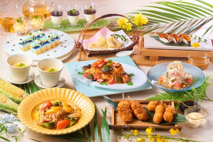 夏グルメバイキングの全品並べ写真。タコのトマトパスタ・揚げたてフライ串・天ぷら・うなぎ寿司・カラフルケーキ・プリン・サラダなど多品目を一覧で収めた料理俯瞰ショット