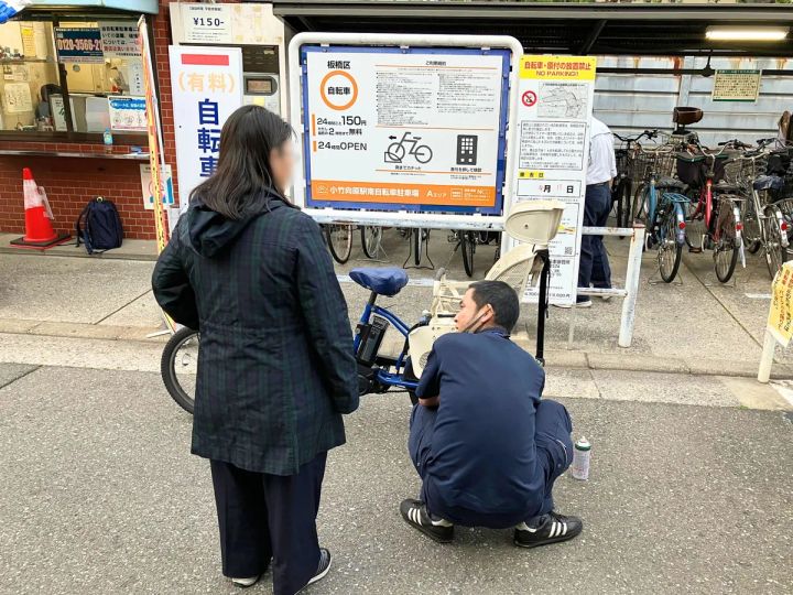 駐輪場で自転車安全整備士が利用者の自転車を点検している様子