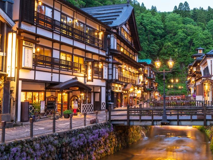 山形県尾花沢市に位置する銀山温泉は、大正ロマンの風情が色濃く残るフォトジェニックな温泉街です。銀山川の両岸に立ち並ぶ木造建築の旅館、夕暮れに灯るガス灯がノスタルジックな雰囲気。日常を忘れ、タイムスリップしたようなひとときを過ごせます。
