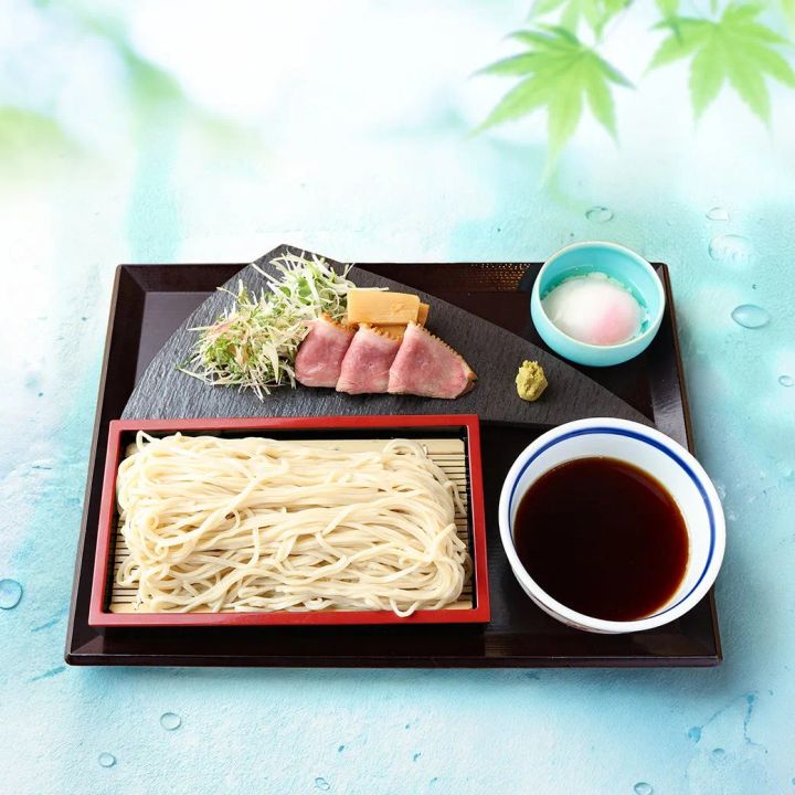 冷やしつけ麺の全体盛り付け写真。蕎麦麺・スライス鴨肉・つけ汁・薬味（ネギ・山椒・おろし大根）が漆塗り膳に並んだ夏の料理ショット