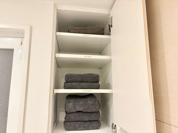 同じ棚にグレーで色を統一したタオルがきれいにたたまれて整然と並んでいる様子