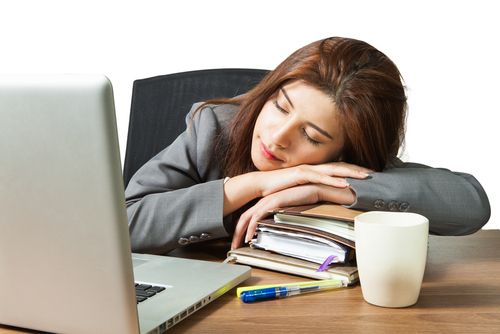 デスクで疲れて眠る女性