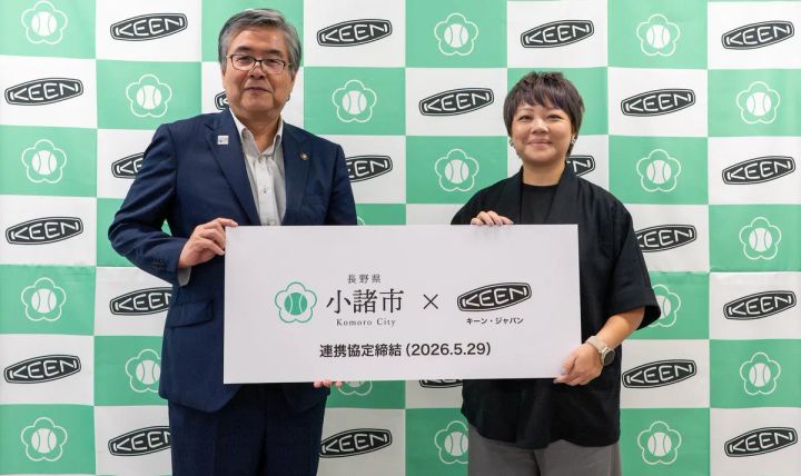 小諸市とキーン・ジャパンの連携協定締結式（2026.5.29）で両者代表者2名がボードを持ってKEEN×小諸市のロゴ入りバックパネルの前に立つ記念撮影