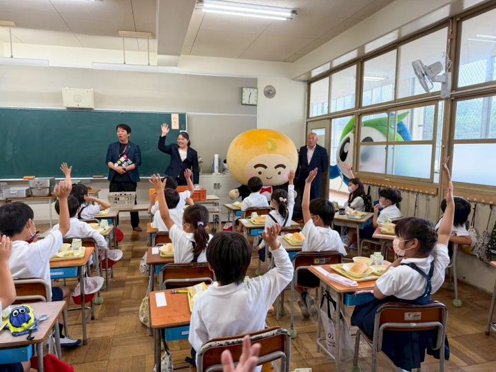 月化粧公式キャラクター「つきろーくん」が小学校を訪問している様子