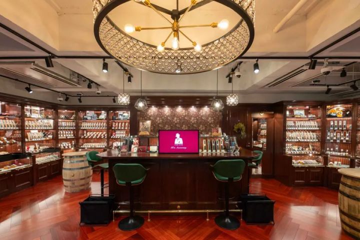 ファイアーキッズ中野ブロードウェイ店の内観全景。中央のアイランドカウンターと四方の木製ガラスケースに多数のヴィンテージ時計が陳列されている
