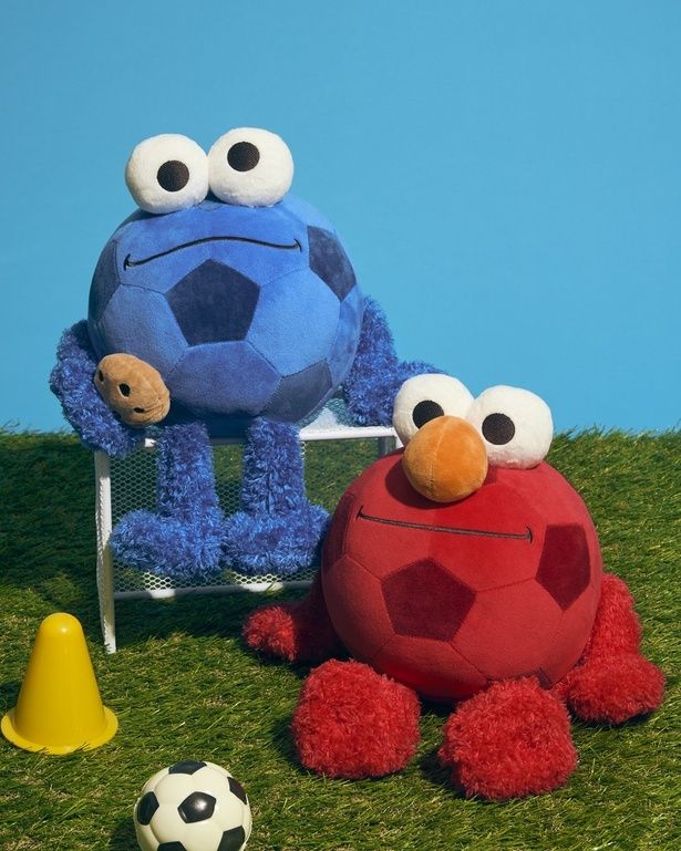 「サッカーボールなりきりぬいぐるみ」(全2種、各4950円)。写真左：ブルー(クッキーモンスター)、同右：レッド(エルモ)