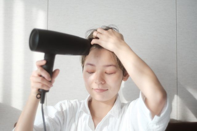 ドライヤーをする女性