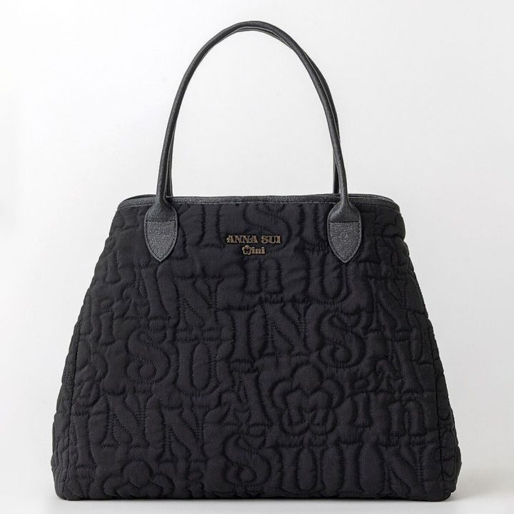 ANNA SUI miniのロゴキルトトートバッグを両サイドのボタンで留めて舟形にした状態。丸みのあるシルエットで黒い持ち手とゴールドのロゴが付いている
