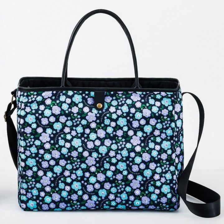 ANNA SUI miniのトートバッグをフラワープリント面にしたリバーシブル状態。紺地にブルーとパープルの花柄が全面に広がり、黒い持ち手とショルダーストラップが付いている
