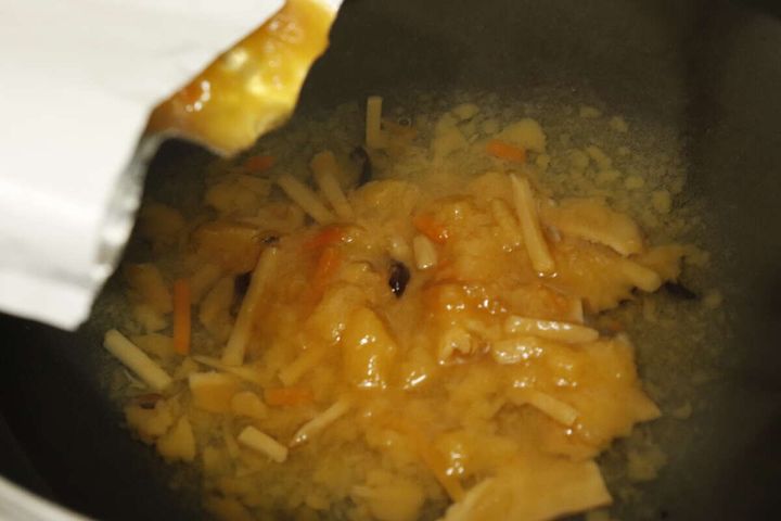 ダイソーのニチレイ 酸辣湯のパウチの中身を鍋に出す様子