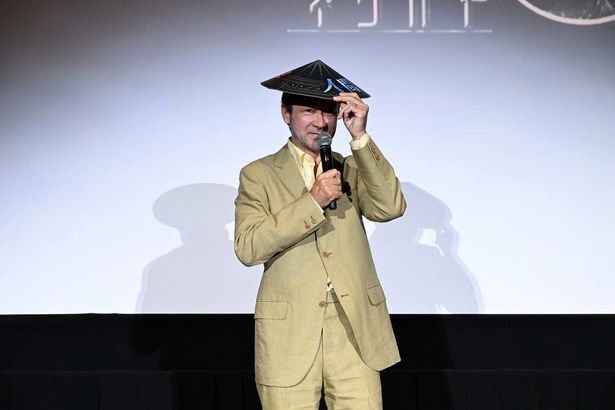 【写真を見る】「天笠」を模した特製アイテムを被る浅野忠信 [c] 2026 Warner Bros. Ent. All rights reserved