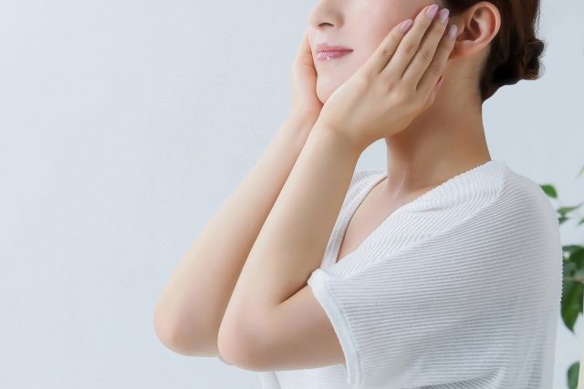 化粧水や下地、日焼け止めを顔にパッティングする女性 美容イメージ