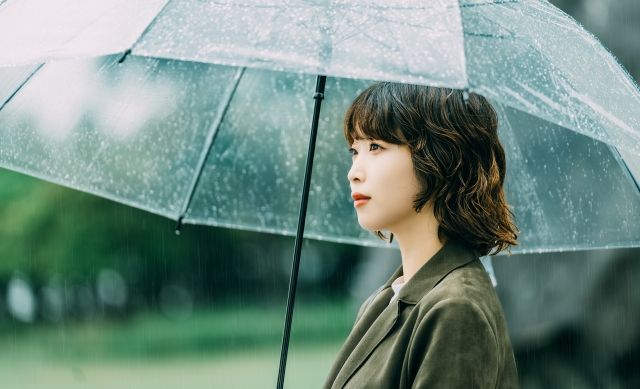 雨の中で傘をさす女性