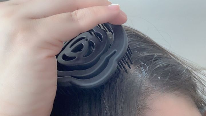 ダイソーの乾きやすいブローブラシ 花型を使って髪を梳く様子