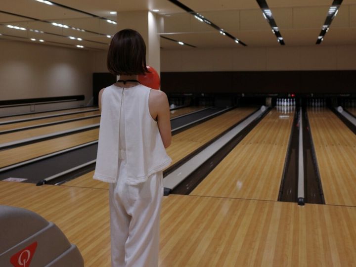 赤沢ボウル オールホワイトコーデでボウリングを楽しむ女性