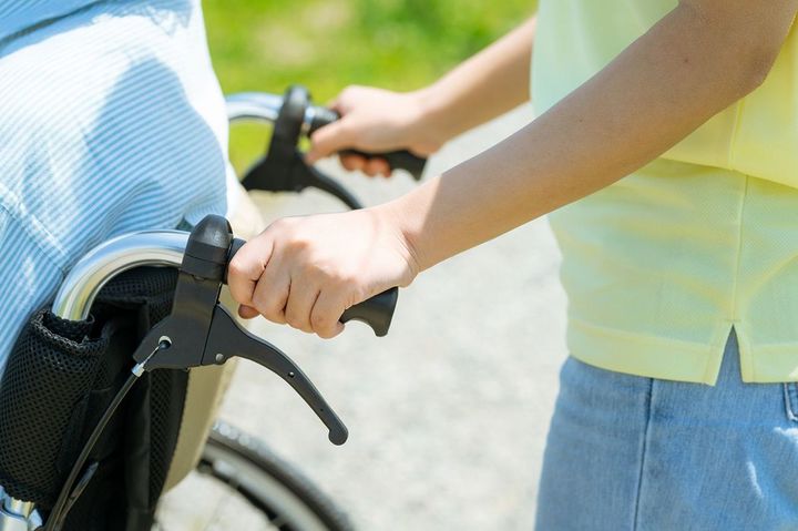 車いすを押す介護者
