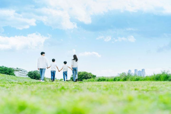 手をつないで公園を歩く家族