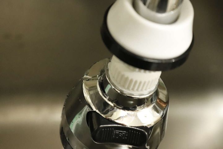 ダイソーの浄水蛇口用首ふりキットの隙間から水が漏れる様子