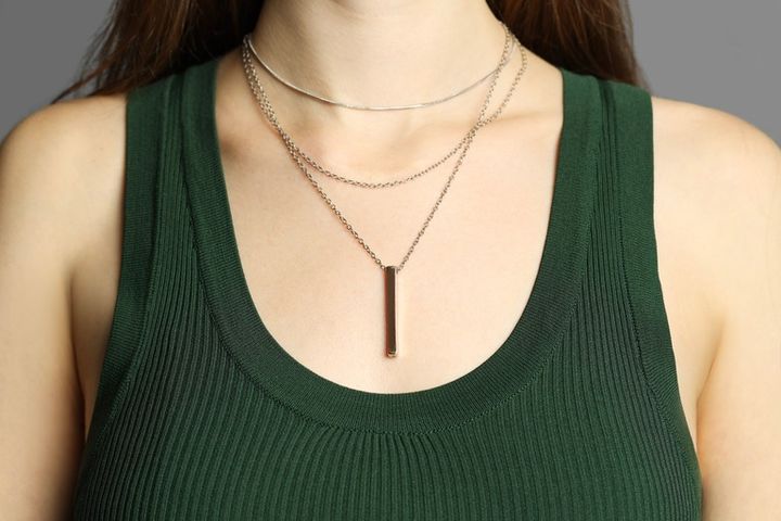 レイヤードのシルバーネックレスをつけた女性
