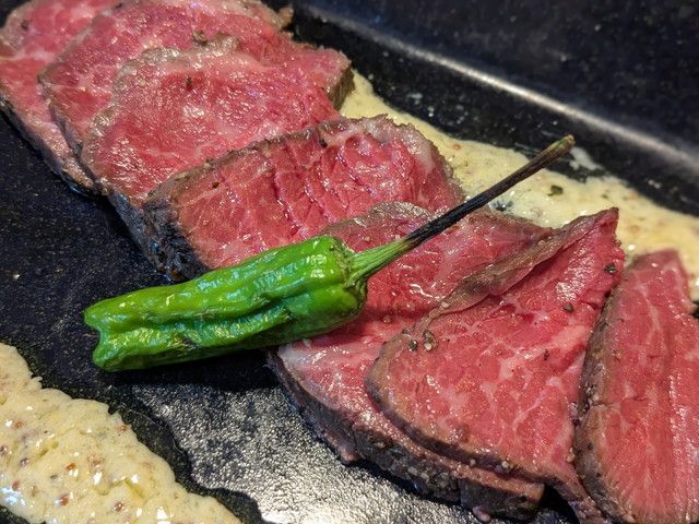 鉄板の上でソースとともに盛り付けられた赤城牛ローストビーフのカット断面。鮮やかなロゼ色が美しい